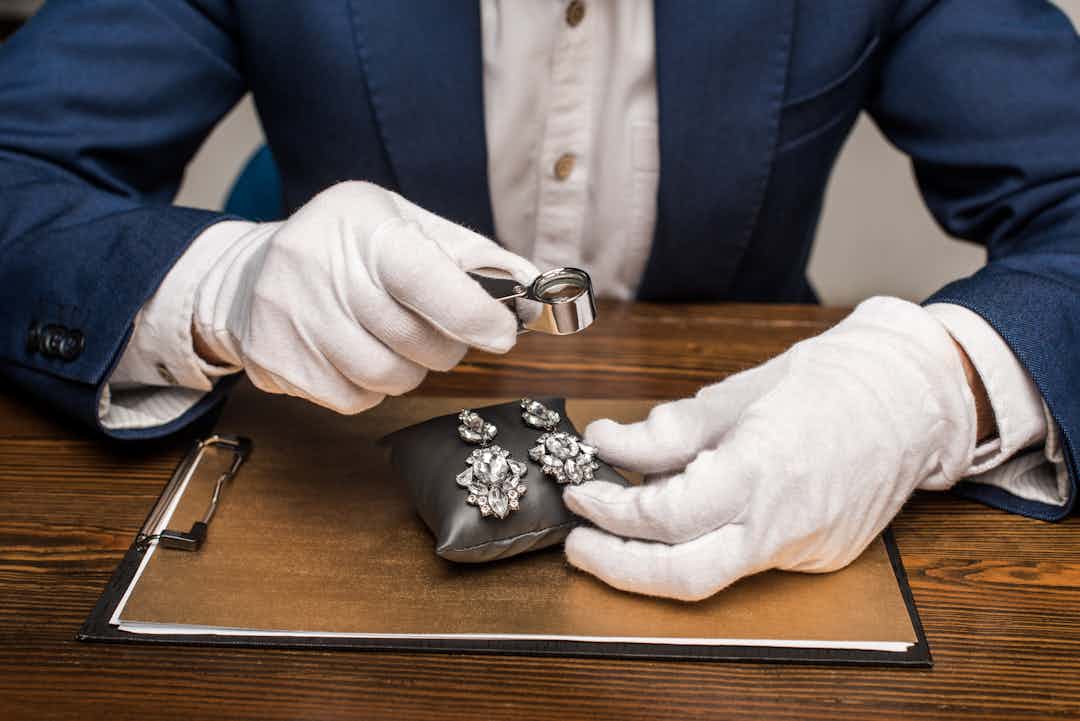 A jewelry appraiser inspecting an item of jewelry for appraisal